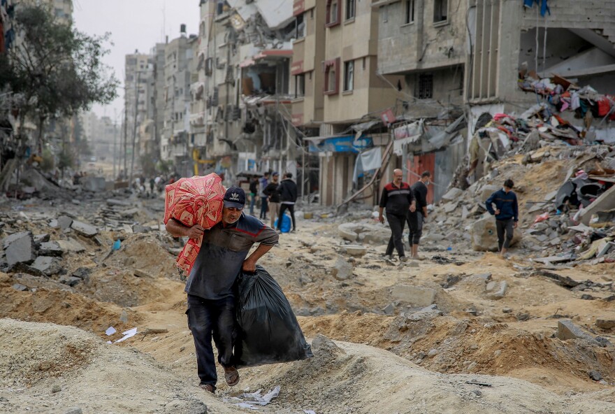 A man walks with personal items as Palestinians leave Gaza City to safer areas in the south on Nov. 25.