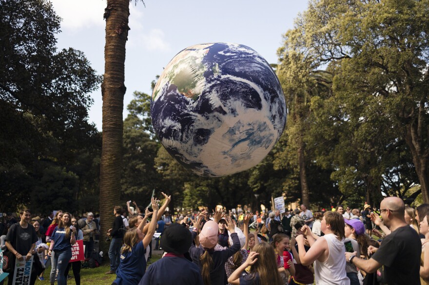 Protesters throw a large globe in Sydney. Rallies held across Australia are part of a global day of action demanding action on the climate crisis.