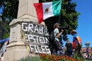 After marching to Indiana University's Sample Gates, a demonstrator holds a Mexican flag in front of a banner that reads, "Grab him by the Epstein files." Another sign read, "Trump is traitor."