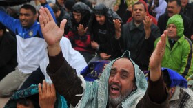 An anti-Gadhafi protester, front, reacts during Friday prayers at the court square in Benghazi, eastern Libya, Friday. Fighters loyal to Gadhafi set up checkpoints in Tripoli ahead of planned anti-government protests Friday.