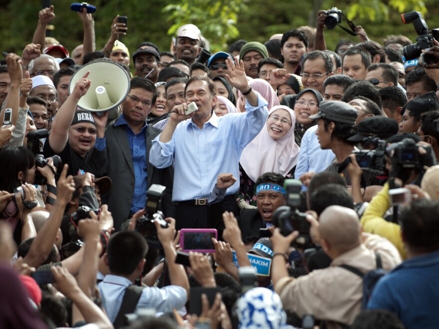 Malaysian opposition leader Anwar Ibrahim (center), accompanied by his wife, Wan Azizah (center right), speaks to his supporters in Kuala Lumpur on Jan. 9 after his acquittal. Anwar is a former student activist — and many say Adam is feared by the government as much as Anwar was.