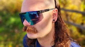 a man with sunglasses and a mullet