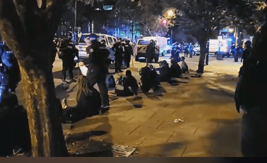 Police monitor a group of protesters whom they've arrested outside of the Main Library in Louisville Thursday night.