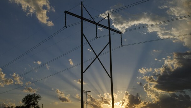 An older transmission power track and power line stands tall against a sunset. (AP Photo/Chuck France)