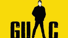 On a vibrant yellow backdrop, stark black lettering poses the question: "What do you do when you lose a son? You do what you do best. GUAC."  The "A" in GUAC is represented by a sketch of a teenage boy, legs spread wide in a relaxed stance. A black beanie covers his head, and his hands rest inside the pockets of his baggy jacket. Basketball shoes complete his casual attire.