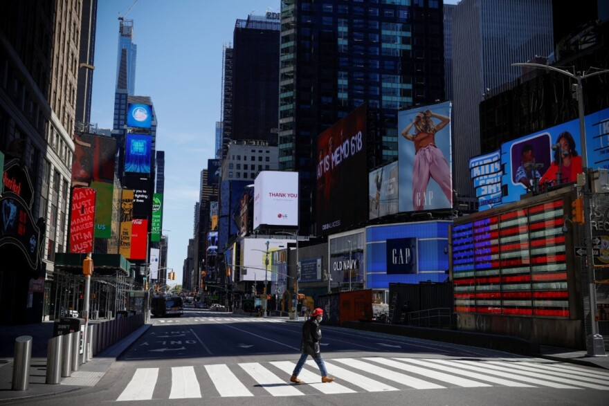 A man wearing a protective face mask crosses 7th Avenue in a nearly deserted Times Square in Manhattan during the outbreak of the coronavirus disease (COVID-19) in New York City, New York, U.S., May 5, 2020. CREDIT: REUTERS/Mike Segar