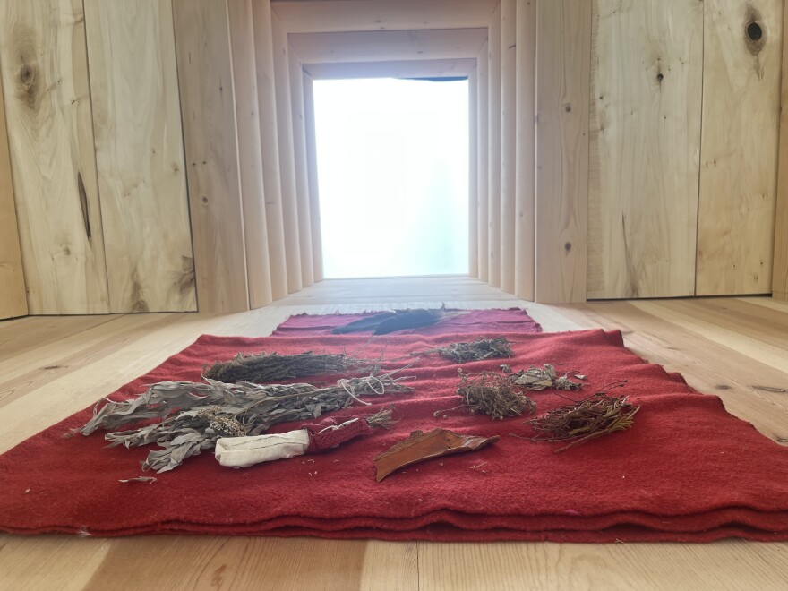 Yéil Yádi Olson is Tlingit Raven from the Kaa Shaayi Hit (Severed Head House). He constructed this seclusion hut in collaboration with curator and healer Meda DeWitt. Olson wanted to use his skills as a carpenter to educate others about indigenous cultures. (Rachel Cassandra/Alaska Public Media)