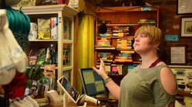 Emily Hall helps a patron at her St. Charles bookstore. She's concerned that a repeal of net neutrality could hurt her ability to reach patrons and event-goers.