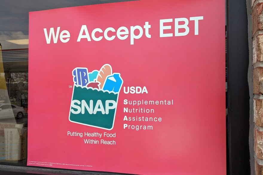 A red sign reads "we accept EBT" with a logo for SNAP benefits and additional text. 