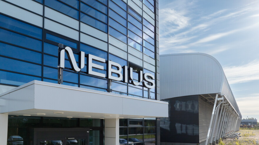 A steel an glass office building with "Nebius" written above the entrance.