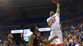 Florida's Justin Leon (24) catches and alley oop pass from teammate Kasey Hill (0) and throws down a monster dunk over Georgia's Kenny Gaines (12). (Greenberry Taylor/WUFT News)