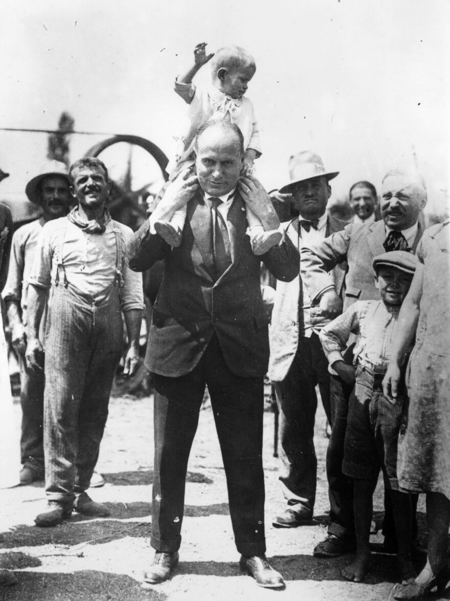 Italian dictator Benito Mussolini holds his son, Romano, on his shoulders in 1935. After his father died, Romano went on to become a jazz musician.