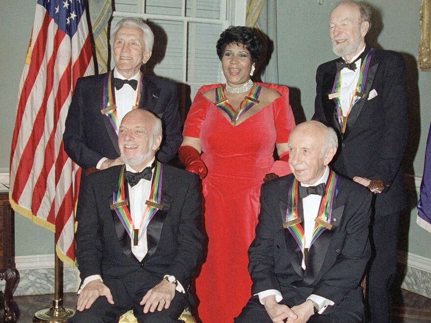 The 1994 recipients of the Kennedy Center Honors pose for a photograph. Hal Prince is seated on the left, next to Morton Gould. Standing, from left to right, are Kirk Douglas, Aretha Franklin and Pete Seeger.