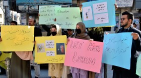 Afghan university students chant slogans and hold placards during a protest against the ban on university education for women. (Arshad Butt/AP)