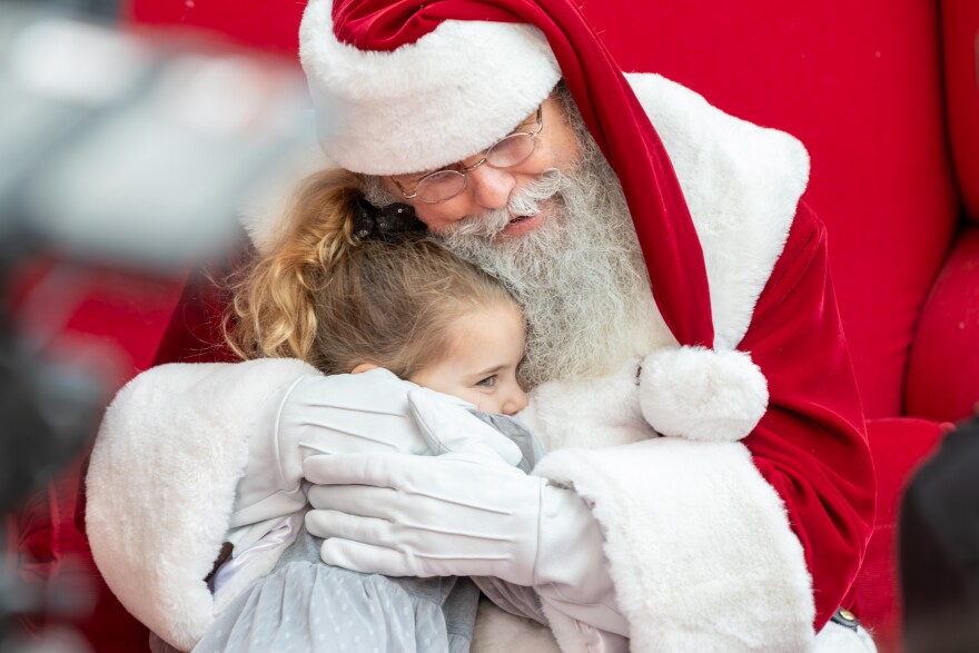 Charles Graves, star of the film "Deaf Santa Claus" hugs a young girl.
