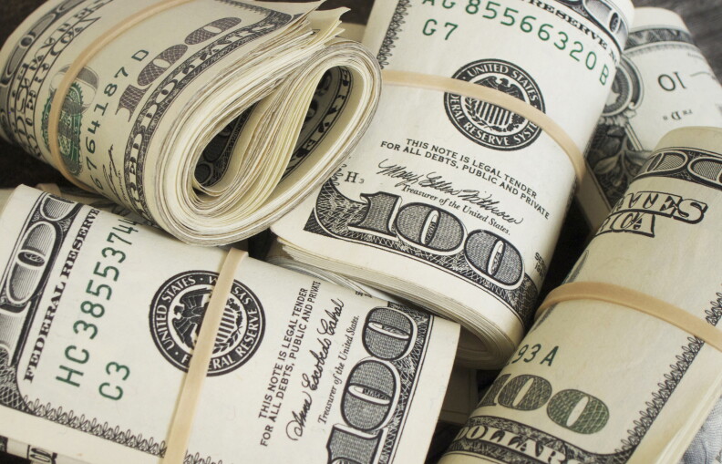 Rolls of money lay next to one another.