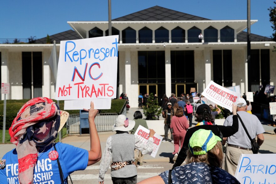 FILE - Demonstrators approach the Legislative Building during a rally protesting a proposed election redistricting map, Oct. 21, 2025, in Raleigh, N.C.