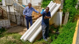 Hannibal 'Mike’ Ware, the newly appointed executive director of the Virgin Islands Waste Management Authority, listens to a government contractor explain the plan for replacing collapsed sewage pipes on a property in Tutu Valley on St. Thomas.
