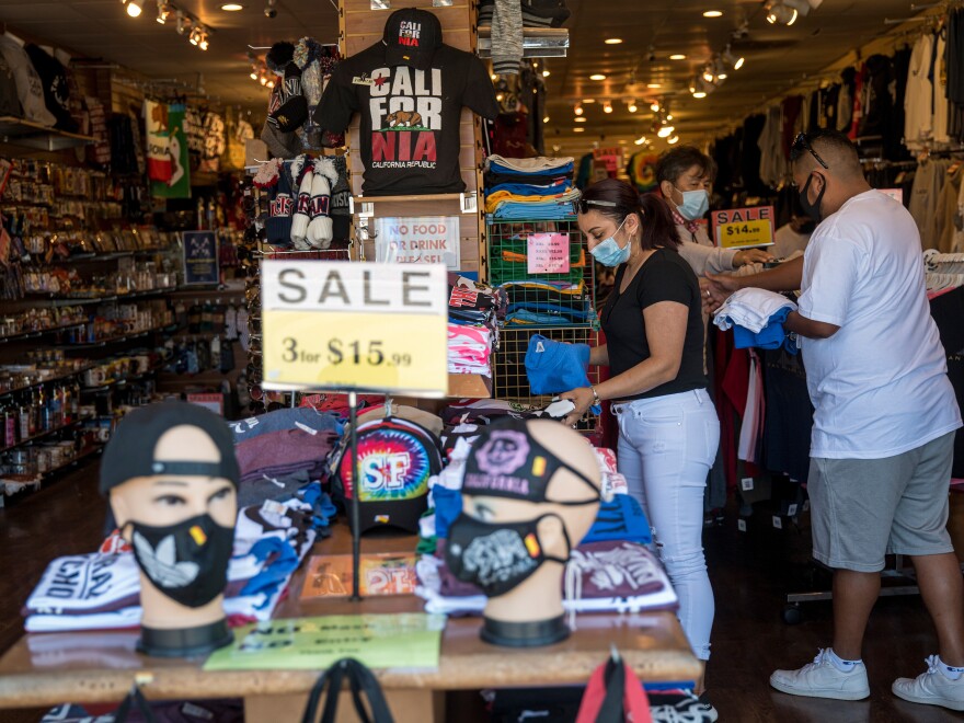 People wearing protective masks shop for clothing at a store on Fisherman's Wharf .