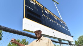 Glasgow resident Don White stands in front of the scoreboard at the high school baseball field dedicated in honor of Negro Leaguer John Donaldson.