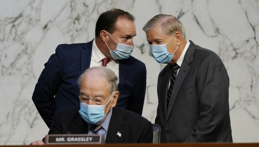 Senate Judiciary Committee Chairman Sen. Lindsey Graham (right) talks to Sen. Mike Lee, R-Utah., as Sen. Charles Grassley, R-Iowa, sits below during Monday's hearing.