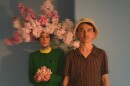 Annakalmia (left)  of the duo Rubblebucket is adorned with flowers while Alex (right) wears a hat.