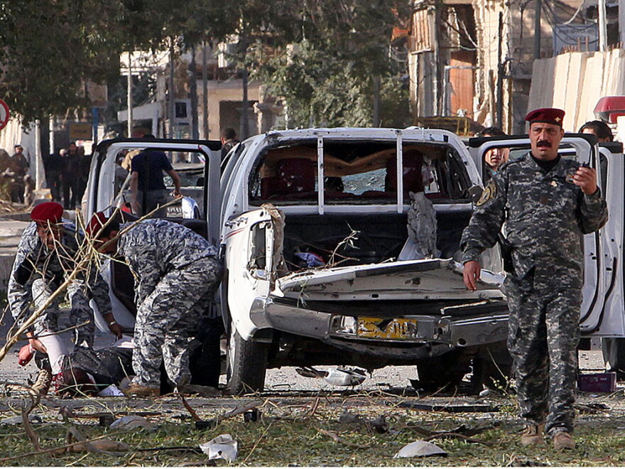 Iraqi police evacuate a victim of bomb attacks in Baghdad.