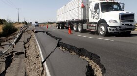 A truck passes damage on a road near San Rafael, 134 miles south of Santiago, the day the 8.8-magnitude earthquake struck central Chile.