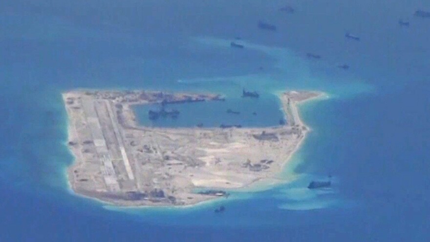 Chinese dredging vessels are purportedly seen in the waters around a reef in the disputed Spratly Islands, in a still image from video taken by a U.S. Navy surveillance aircraft in May. China says a U.S. bomber got too close to one of the islands.