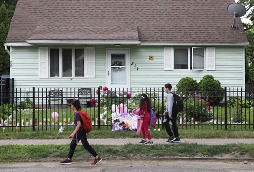A group of children walk past a house on 221 Emerson St. where 16-year-old Zahira Smith was shot while attending a birthday party.