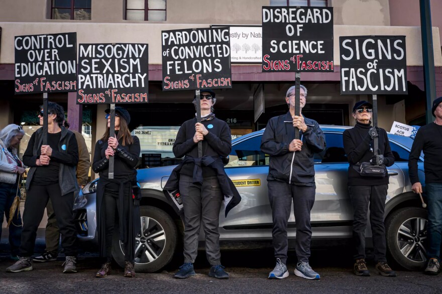 People hold signs protesting Supreme Court Justice Amy Coney Barrett's appearance at the Lensic Performing Arts Center on Sunday.