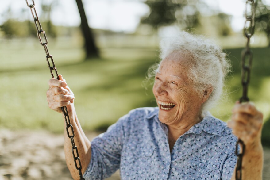 Elderly lady swinging in a park.