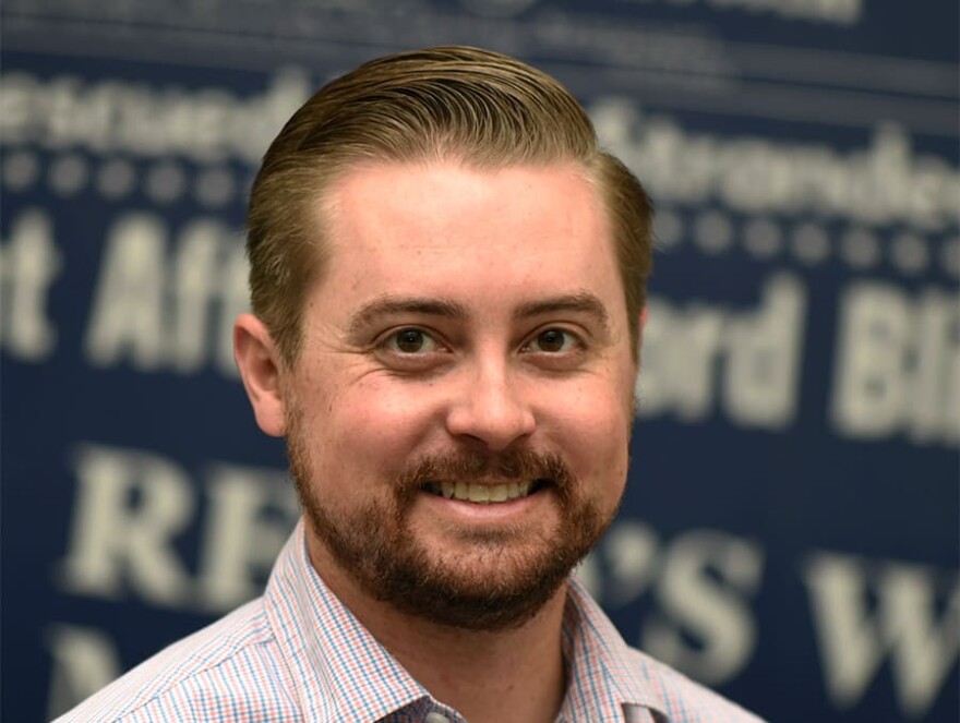 A professional headshot for Brian Duggan, incoming KUNR general manager. He is looking toward the camera and smiling.