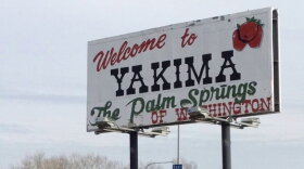 A billboard against a cloudy sky with text saying "Welcome to Yakima the Palm Springs of Washington. 