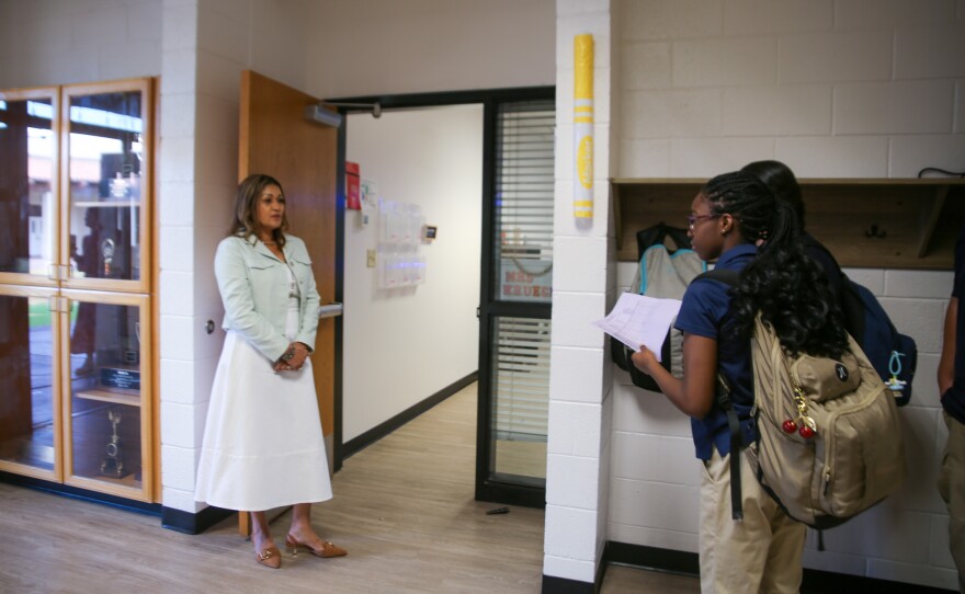 Lorena Krueger (left) waits outside her classroom.