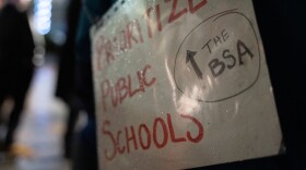 A sign worn by a protestor at the Alaska State Capitol on Jan. 29, 2024 calls for an increase in education funding. (Eric Stone/Alaska Public Media)