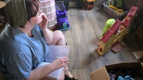 Wren Medina making a spot on the floor for him to write at home.