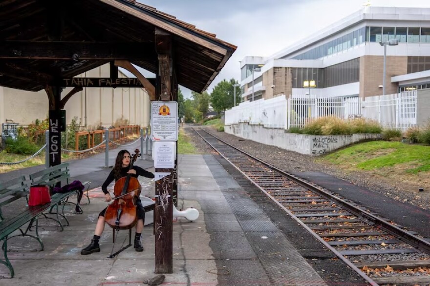 Andrea González plays Heitor Villa-Lobos' “O Canto do Cisne Negro” (The Song of the Black Swan) outside the U.S. Immigration and Customs Enforcement in Portland, Ore., on Tuesday, Oct. 7, 2025. González says she hopes to bring comfort to those coming to the facility for an appointment, and she hopes "to give them a little bit of reassurance, like, 'Hey, you're not alone. I'm here. I'm watching what's happening and I'm supporting you.'"