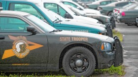 A photo of the front of a New Hampshire State Police Cruiser parked next to others.