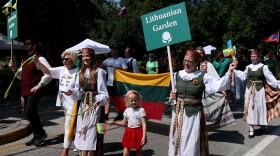 People marching in a parade carrying flags