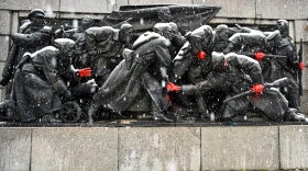 A picture taken shows the figures of Soviet soldiers freshly painted with red hands at the base of the Soviet Army monument in Sofia in reaction to Russia's invasion of Ukraine.