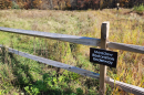 A fenced area with a sign that says "Meadow Restoration Underway"