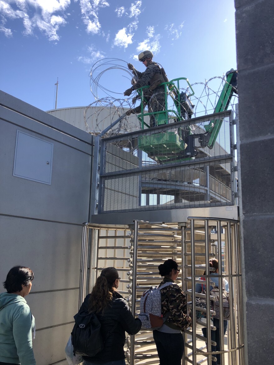 Marines install concertina wire at the San Ysidro, Calif., port-of-entry, as people enter a secure area en route to Mexico. San Ysidro is the world's busiest border crossing.