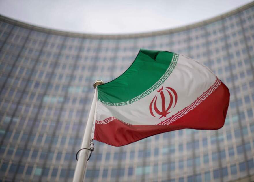 A national flag of Iran waves in front of the building of the International Atomic Energy Agency, IAEA, in Vienna, Austria, Dec. 17, 2021. (Michael Gruber/AP)