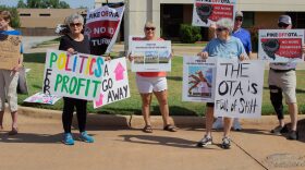 Pike Off OTA demonstrators hold signs outside of the Association of Oklahoma General Contractors.