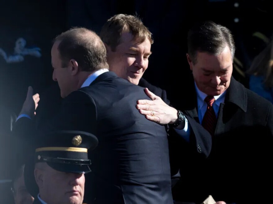 Gov. Jared Polis, possibly wearing a bullet proof vest, greets U.S. Sen. Michael Bennet during the swearing-in ceremony, Tuesday, Jan. 10, 2023, at the Colorado State Capitol in Denver.