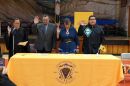 A woman wearing judge’s robes leads two men and a woman in an oath of office in an auditorium.