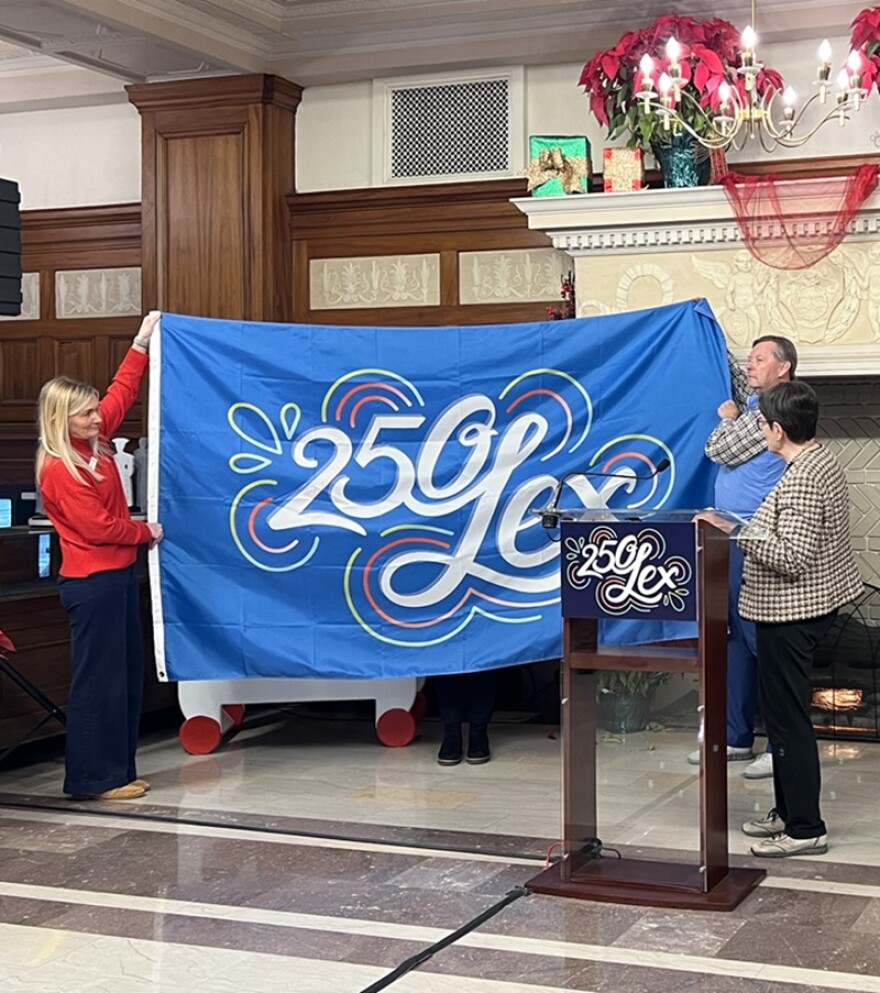 Lexington Mayor Linda Gorton (right) and others unveiled the official flag for the city's 250 anniversary celebration Monday in city hall.