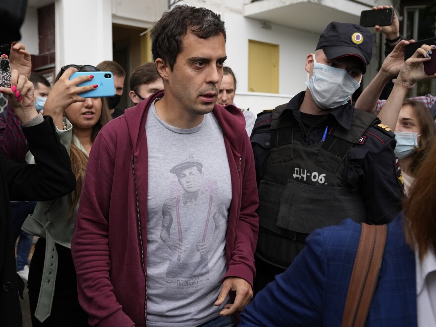 Roman Dobrokhotov, chief editor of <em>The Insider,</em> walks surrounded by police and journalists, in Moscow on Wednesday. Police raided his home after the<em> </em>investigative news organization was designated as a "foreign agent." Last week, it became the 16th media outlet to be added to the Russian Justice Ministry's foreign agents list.