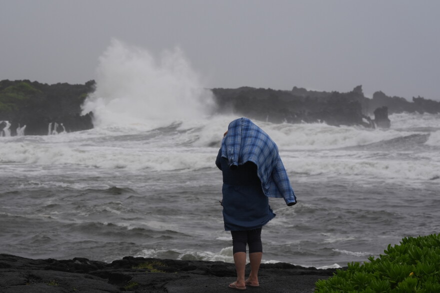 A woman watches waves breaking at Punalu'u Beach as Hurricane Nolo sits nearby Saturday, Sept. 26, 2026, near Pahala, Hawaii. (AP Photo/Gregory Bull)